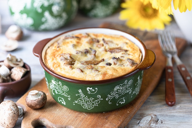 Tarte quiche aux champignons sur une table en bois.