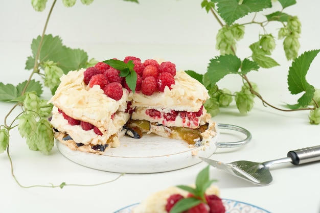 Tarte ronde à la meringue aux framboises fraîches sur fond blanc Pavlova dessert