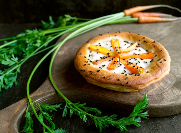 Tarte rustique aux carottes. Sur un fond sombre.