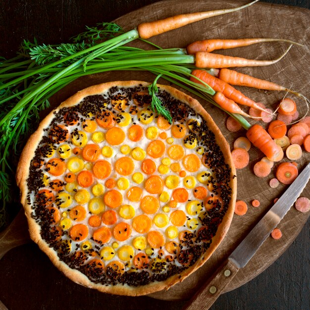 Tarte rustique aux carottes. Sur un fond sombre.