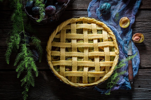 Tarte rustique et maison aux prunes sur toile bleue