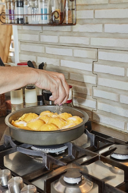 Tarte tatin Tarte aux pommes française Chef met le sucre en poudre dans le moule à tarte