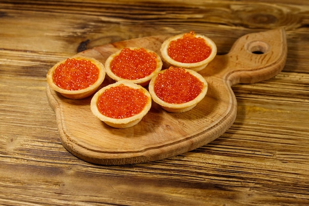 Tartelettes au caviar rouge sur une table en bois