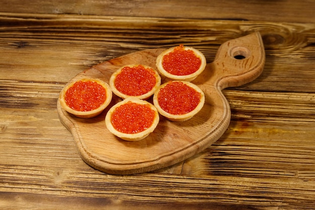 Tartelettes au caviar rouge sur une table en bois