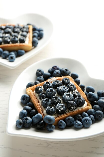 Tartelettes aux bleuets frais gastronomiques sur des assiettes en gros plan