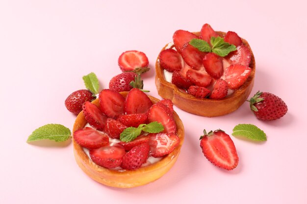 Tartelettes aux fraises sur fond rose, gros plan.