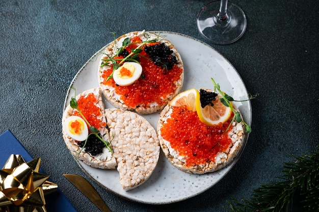 Tartelettes concept nouvel an et joyeux Noël avec champagne caviar rouge et décor de Noël Gâteau de riz au caviar apéritif de Noël