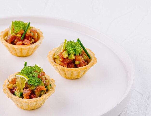 Photo des tartelettes de légumes frais sur une assiette blanche