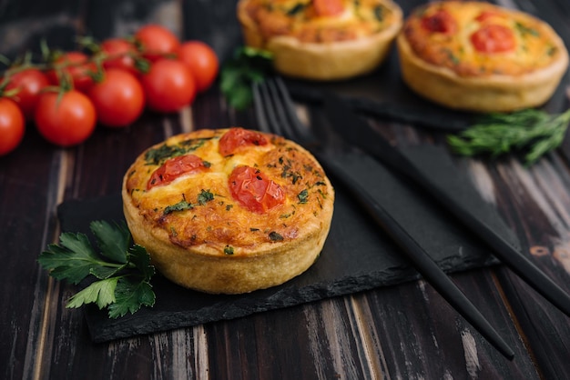 Tartelettes d'omelette au fromage cheddar et à l'oignon de printemps servies sur planche de bois