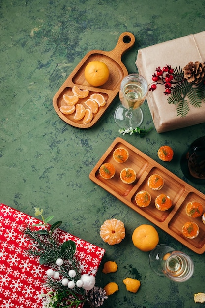 Photo tartelettes vertes de fond de noël avec des mandarines de caviar rouges et du champagne