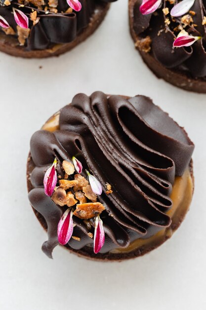 Des tartes au chocolat décorées de ganache au chocolat noir sur un fond blanc Close Up Vue supérieure