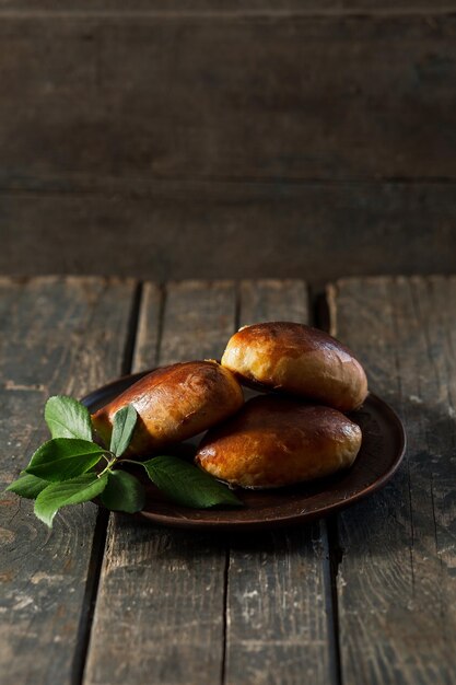 Tartes au four sur une plaque d'argile brune sur une table en bois