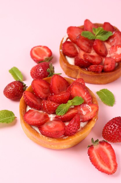 Tartes aux fraises sur fond rose, gros plan.