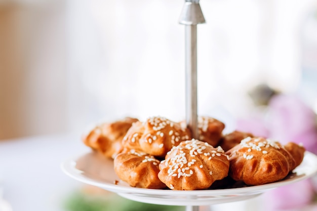 Tartes aux graines de sésame sur une assiette à plusieurs niveaux. Table de buffet à la fête.