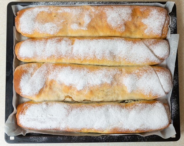 Les tartes aux pommes et aux graines de pavot se trouvent sur un plateau du four