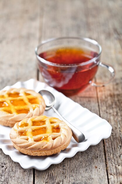 Tartes fraîches cuites au four avec garniture de marmelade ou d&#39;abricot sur une assiette en céramique blanche.