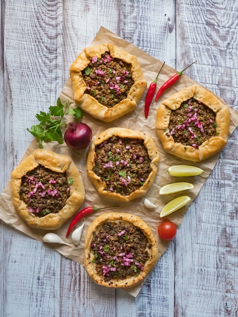 Tartes à la viande libanaises traditionnelles sur une table en bois