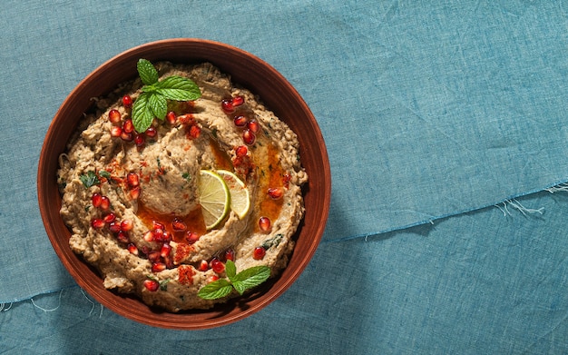 Tartinade maison de baba ganoush aubergine cuit au four dans un bol avec des graines de grenade