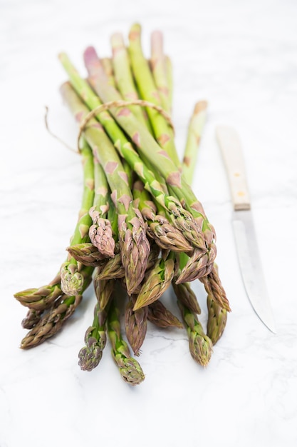 Tas d'asperges du jardin crues fraîches avec couteau