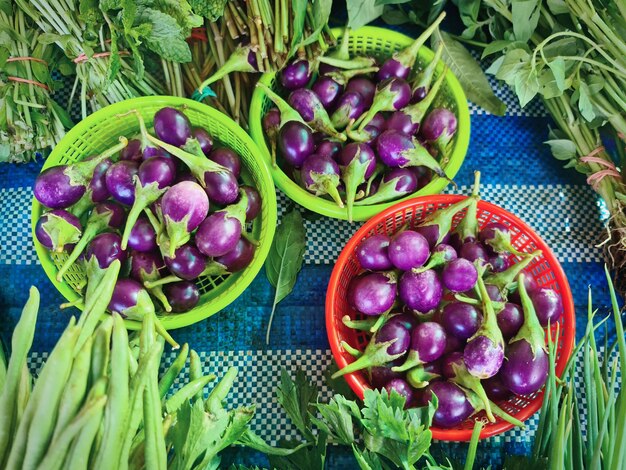 Tas d'aubergines violettes fraîches dans des paniers à vendre à Market Stall