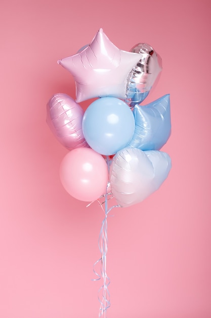 Un tas de ballons bleus roses sur une surface rose