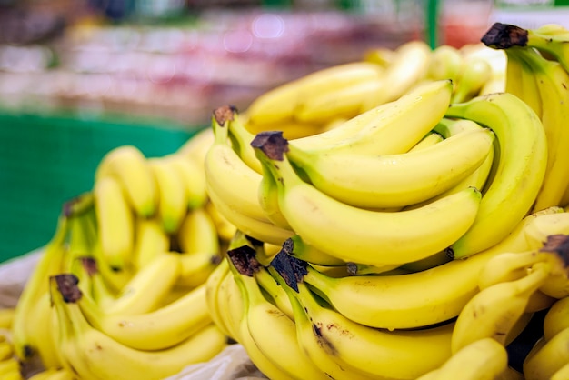 Tas de bananes en hypermarché contre des étagères floues