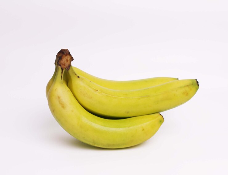 Photo un tas de bananes sont assis sur un fond blanc.