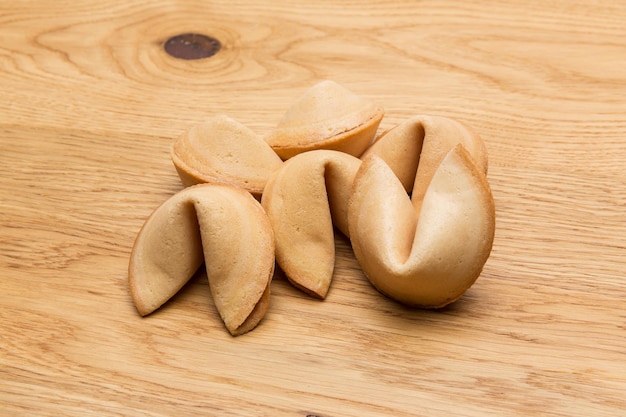 Un tas de biscuits de fortune sur un fond de table en bois. Pris en studio avec une marque 5D III.