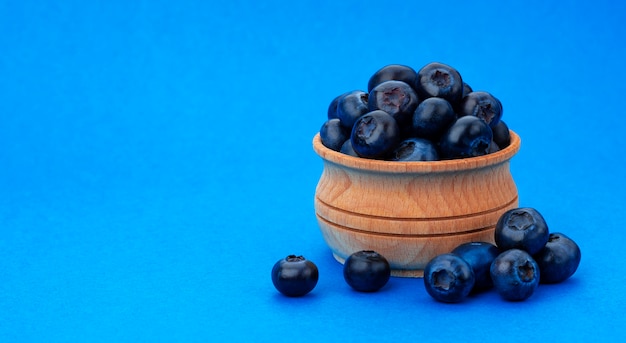 Un tas de bleuets frais dans un bol en bois