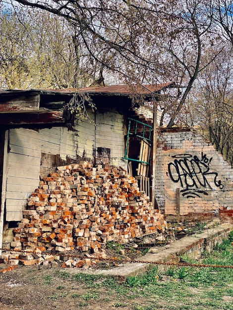 Tas de bois de chauffage devant une vieille maison abandonnée