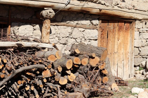 Tas de bois de chauffage empilé près du mur de la maison rurale