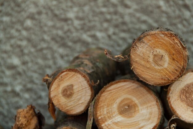 Tas de bois de chauffage sur un fond de mur gris Bois de chauffage rond sur un fond de pierre grise