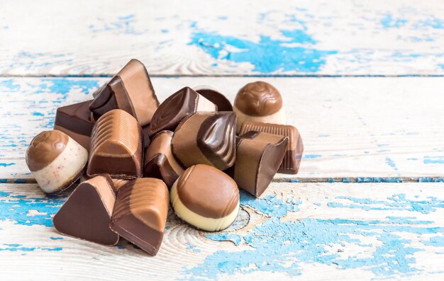 Tas de bonbons au chocolat sur le vieux fond de bois bleu