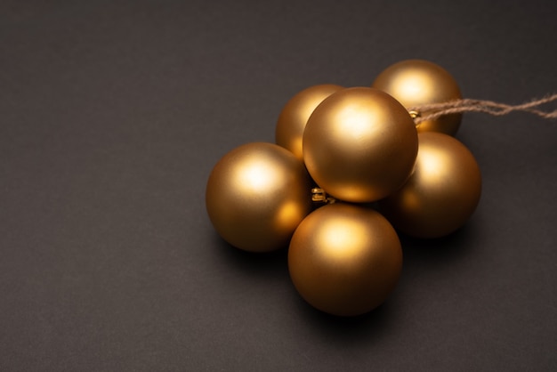 Un tas de boules de Noël d'or sur fond sombre