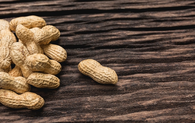 Tas de cacahuètes, pile d&#39;arachides sur une table en bois