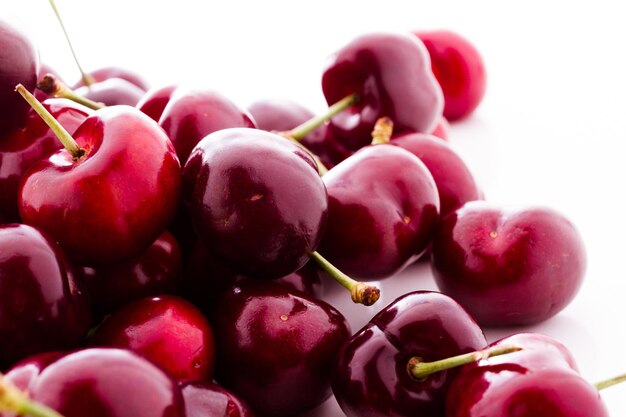 Tas de cerises fraîches sur fond blanc.