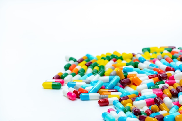 Tas De Comprimés De Capsules Antibiotiques Multicolores Sur Fond Blanc. Médicament Antibiotique.