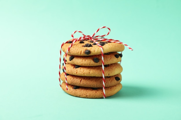 Tas de cookies aux pépites de chocolat sur fond de menthe