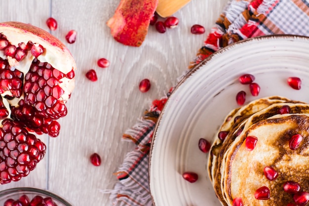 Un tas de crêpes avec des graines de grenade sur une assiette