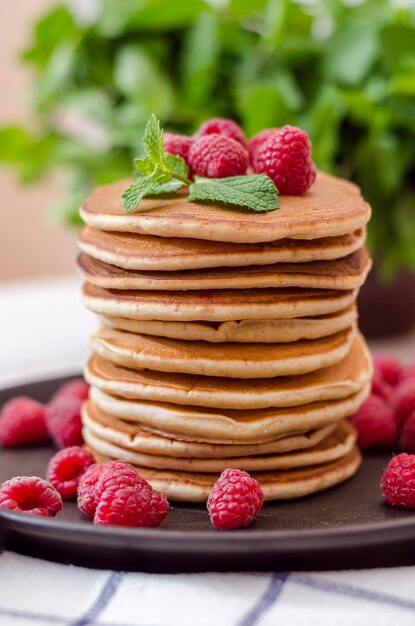 Tas de crêpes à la vanille dans une poêle avec framboises, myrtilles et mûres au sommet.