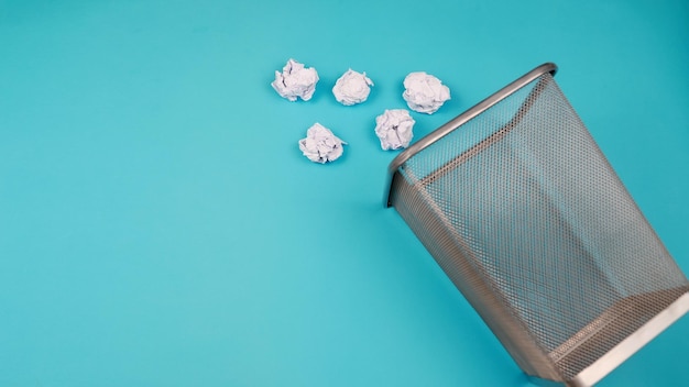 Des tas de déchets sont jetés hors de la poubelle Pour un espace de copie pour les concepteurs sur fond bleu