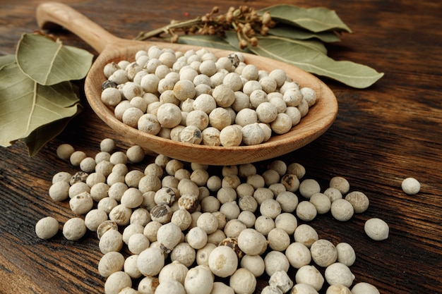 Tas d'épices de poivre blanc sur table en bois