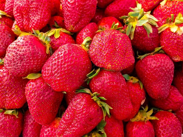 Photo un tas de fraises avec des feuilles vertes sur elles