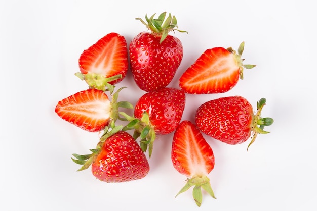 Un tas de fraises mûres sur un gros plan de fond blanc