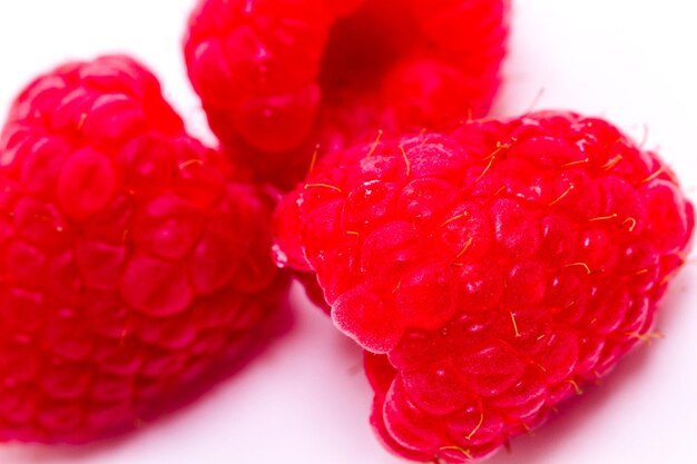 Tas de framboises biologiques sur fond blanc.