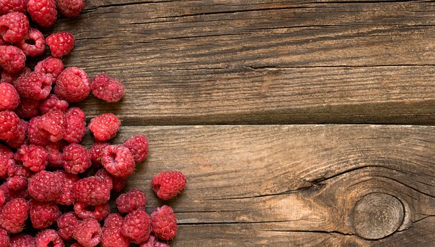 Tas de framboises fraîches sur un fond en bois.