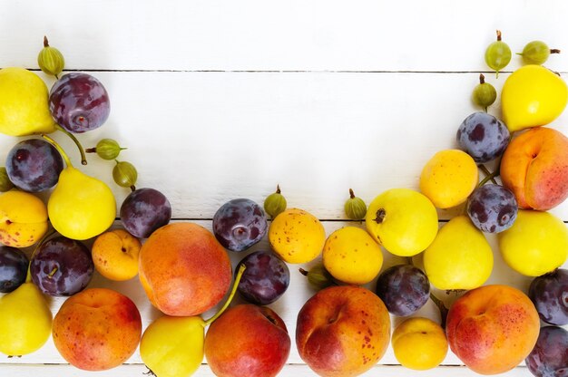 Tas de fruits d'été juteux sur une table en bois blanc