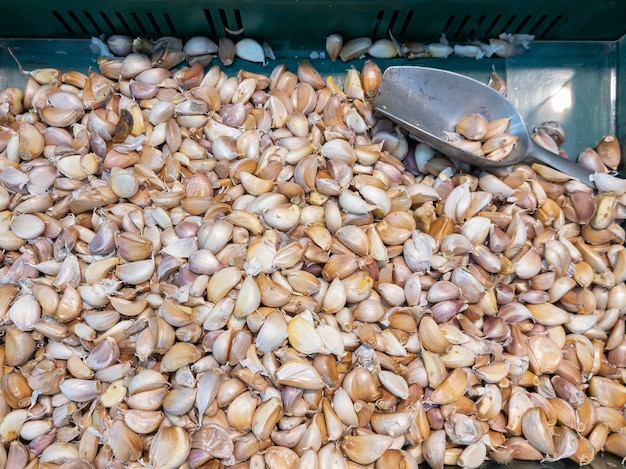 Photo tas de gousses d'ail avec scoop à vendre dans un panier au supermarché