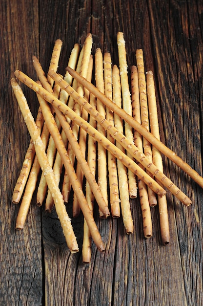 Tas de gressins salés sur table en bois sombre