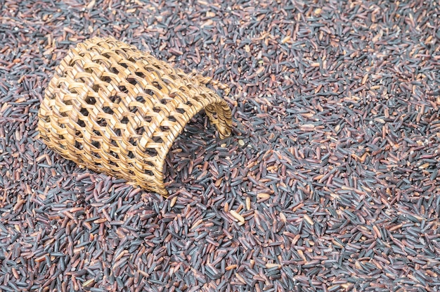 Tas de gros plan de riz noir appelé rizberryberry avec osier en bois